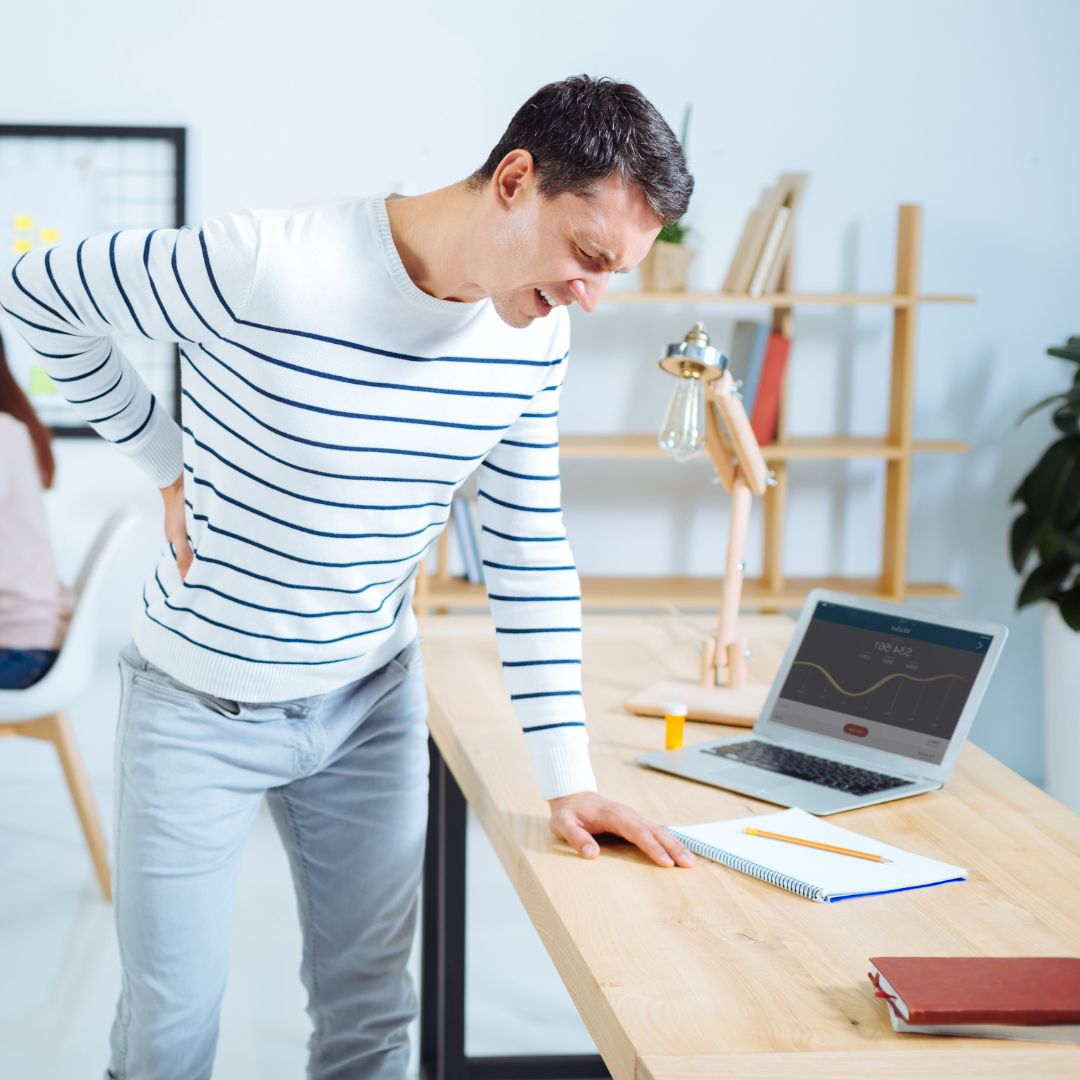 Man suffering from back pain due to long hours of office work
